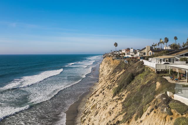 Aerial view of the cliffs, the surf and palm trees in Encinitas.