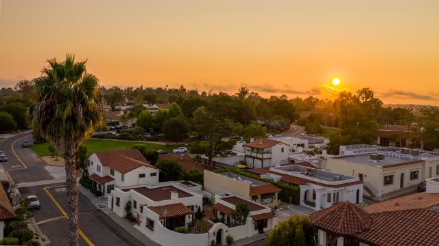 Low aerial view of a residential street, palm trees and homes at Covenant.
