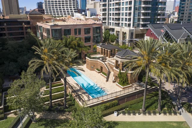 Low aerial view of the downtown streets, the skyline and palm trees at San Diego Marina.