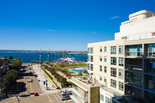 Low aerial view of the downtown streets, boats and palm trees at Waterfront, with people walking.