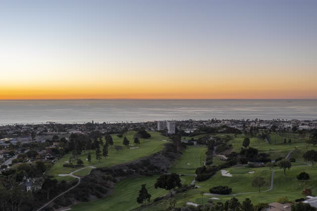 Aerial view of a residential street, palm trees and the ocean at La Jolla Country Club.