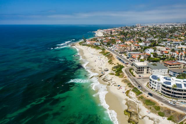 Aerial view of the beach, the surf and the ocean at Windansea, with people walking.