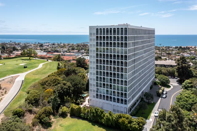 Aerial view of a residential street, palm trees and the ocean at La Jolla Country Club.