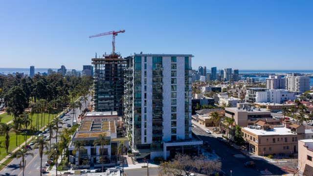 Aerial view of the downtown streets, the skyline and palm trees at Bankers Hill, with a work crew on site.