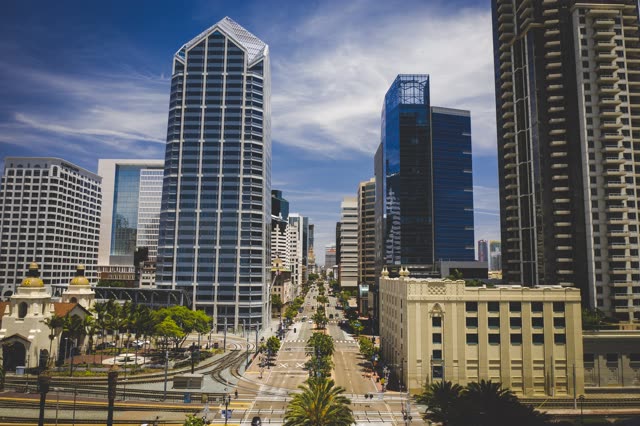 Low aerial view of the downtown streets, the skyline and palm trees at Waterfront.