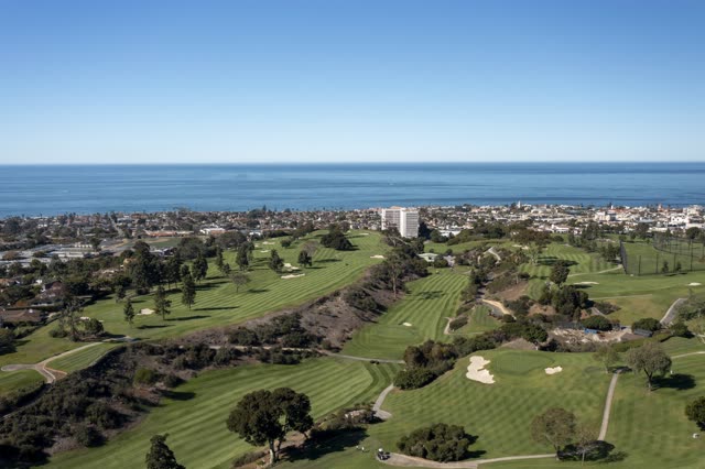 Aerial view of the country inland, the ocean and homes at La Jolla Country Club.