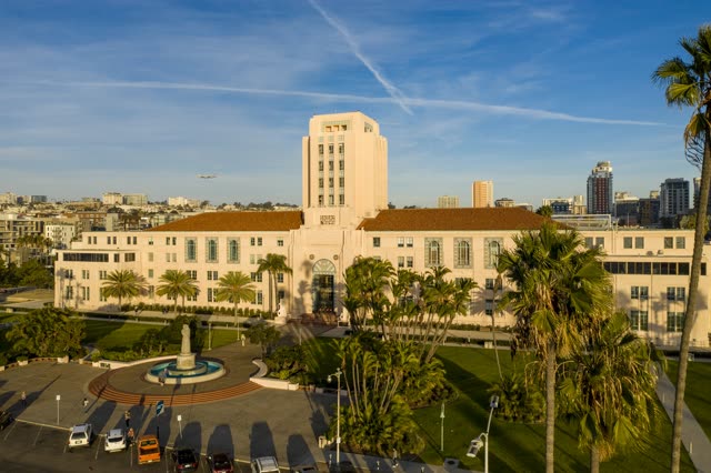 Low aerial view of the downtown streets, the skyline and palm trees at Waterfront, with people walking.