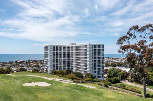 Aerial view of a residential street, palm trees and the ocean at La Jolla Country Club.