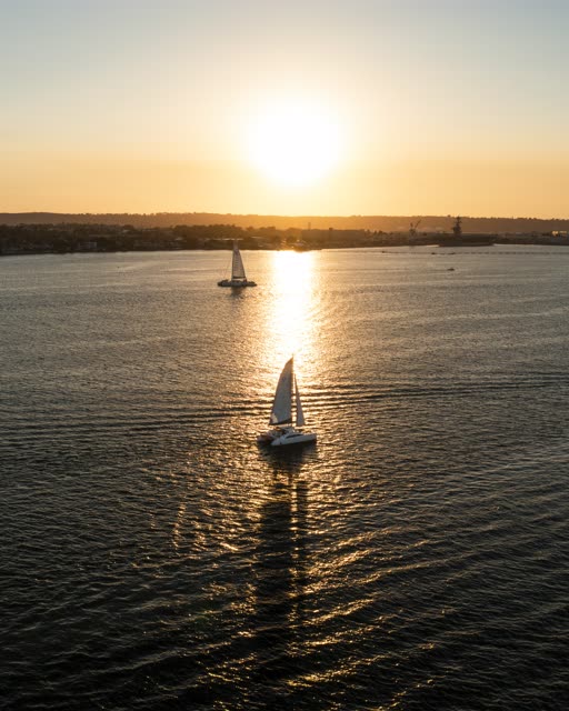 Low aerial view of the harbor, boats and the bay at San Diego Marina, with boats out.