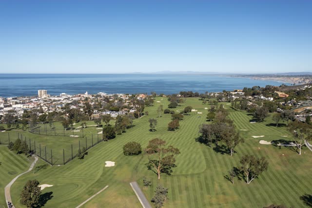 Aerial view of the country inland, the ocean and homes at La Jolla Country Club.