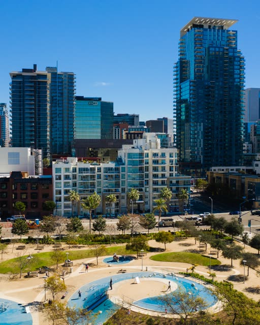 Low aerial view of the downtown streets, the skyline and palm trees at Waterfront, with people walking.