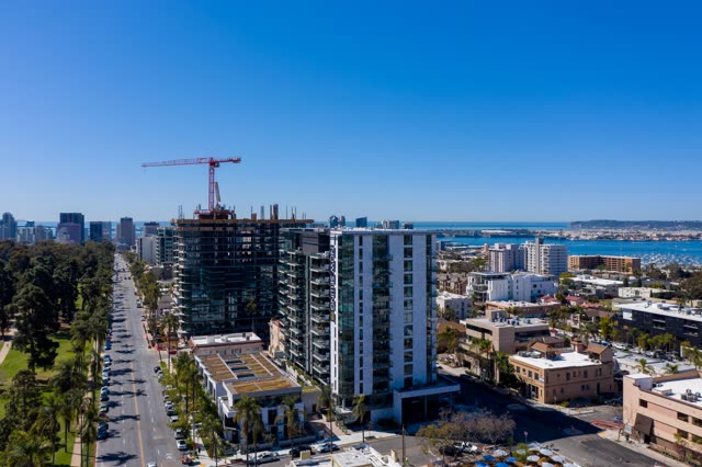 Aerial view of the downtown streets, the skyline and palm trees at Bankers Hill, with a work crew on site.