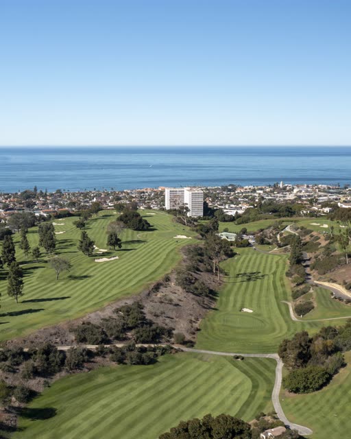 Aerial view of the country inland, the ocean and homes at La Jolla Country Club.