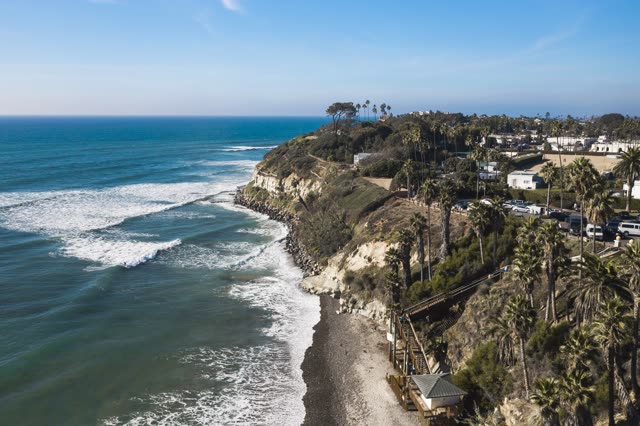 Aerial view of the cliffs, the surf and palm trees at Swamis.