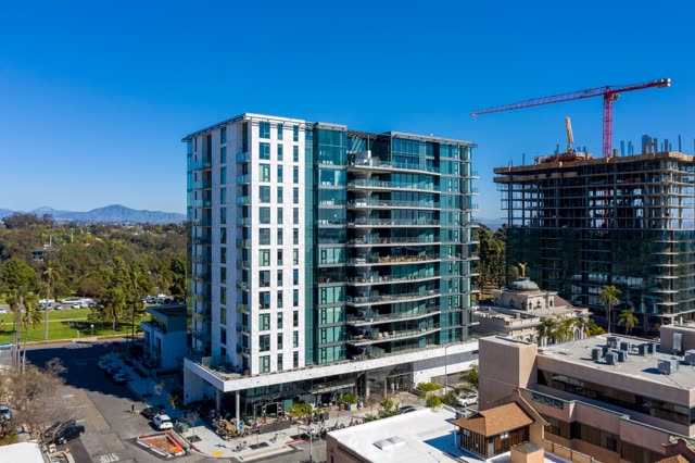 Aerial view of the downtown streets, the skyline and palm trees at Bankers Hill, with a work crew on site.