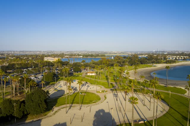 Aerial view of a park, palm trees and the bay in Mission Bay, with people walking.