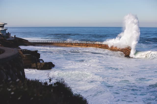 Elevated view of the cliffs, the surf and the ocean at La Jolla Cove.