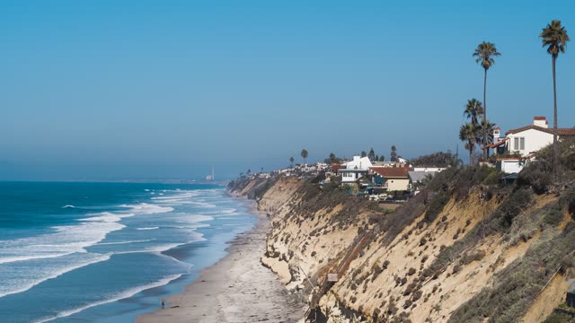 Elevated view of the cliffs, the surf and palm trees in Encinitas.