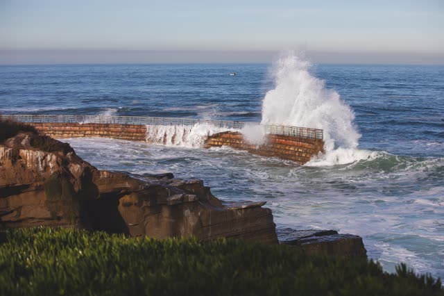 Elevated view of the cliffs, the surf and the ocean at La Jolla Cove.