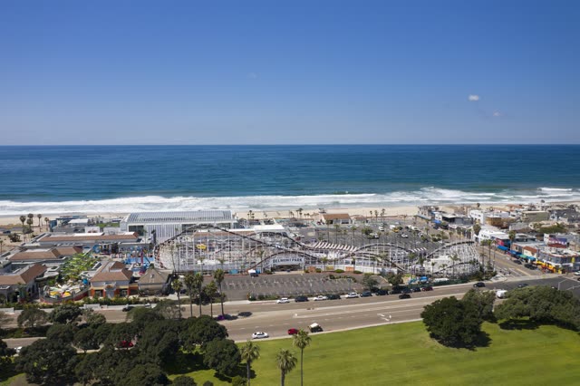 Aerial view of the beach, the surf and palm trees at Belmont Park.