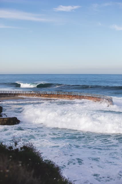 Elevated view of the cliffs, the surf and the ocean at La Jolla Cove.