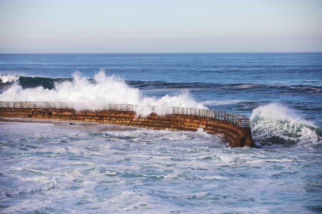 Elevated view of the cliffs, the surf and the ocean at La Jolla Cove.