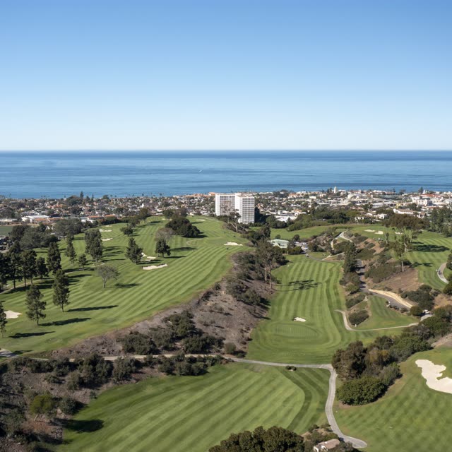 Aerial view of the country inland, the ocean and homes at La Jolla Country Club.