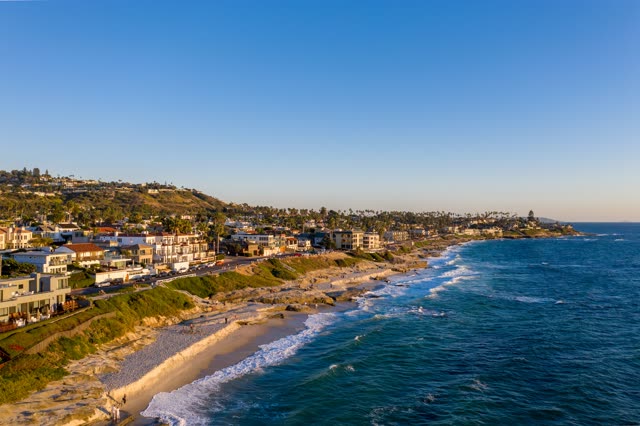 Aerial view of the cliffs, the surf and palm trees at Windansea.