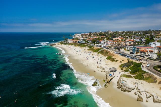 Aerial view of the beach, the surf and the ocean at Windansea, with people walking.