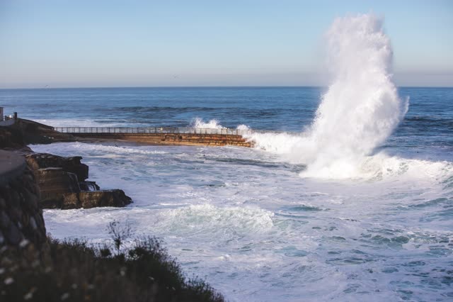 Elevated view of the cliffs, the surf and the ocean at La Jolla Cove.