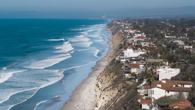 Aerial view of the cliffs, the surf and palm trees in Encinitas.